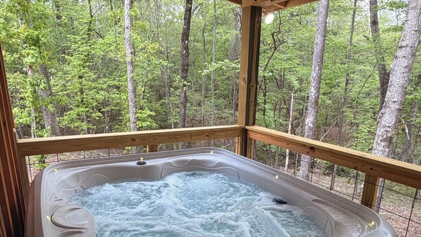 Ein Whirlpool mit Holzterrasse und Blick ins Waldgebiet.