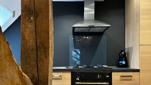 A modern kitchen with a stove, oven, and black range hood.