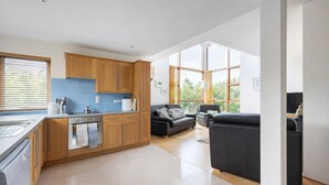 Eine moderne Küche mit Holzausbau, einem Backofen und einem großen Fenster.