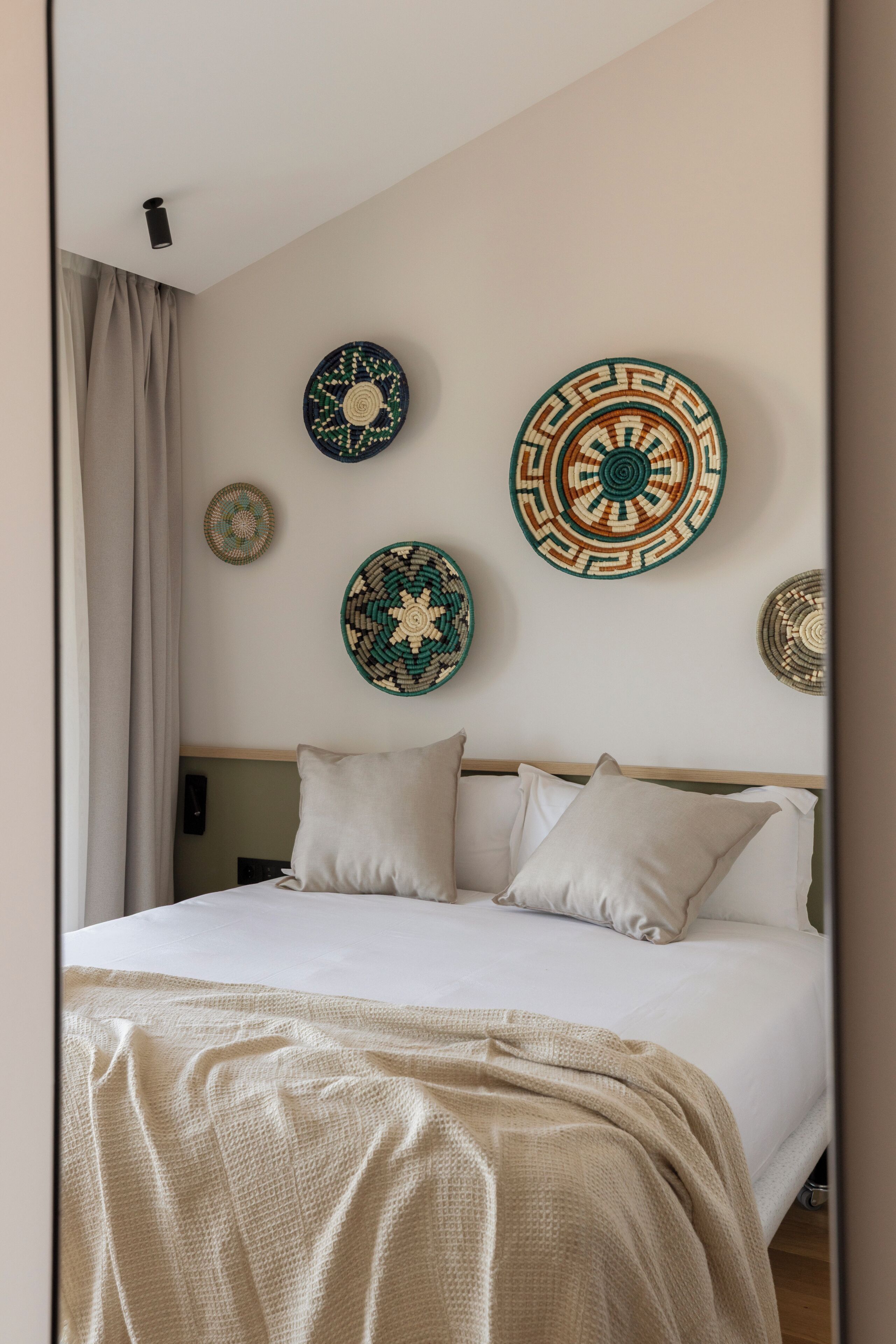 Ein Schlafzimmer mit einem Bett, Kissen und dekorativen Wandgestaltungen.