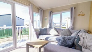 Et værelse med en sofa, et lille bord og udsigt ud