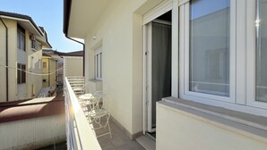 A balcony with a white metal chair, a small table, and a window with a curtain. - B002 - Bellaria, large apartment close to the sea (Bellaria)