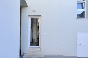 A white door with a small window, a number '9' sign, and a light fixture above it. - B002 - Bellaria, large apartment close to the sea (Bellaria)