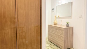 A wooden wardrobe, a wooden vanity with a mirror, and a geometric patterned floor. - B002 - Bellaria, large apartment close to the sea (Bellaria)