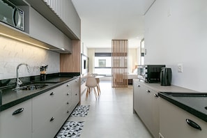 A modern kitchen with a microwave, sink, and coffee maker.