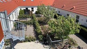 Een binnentuin met een trap, een boom en een fiets.