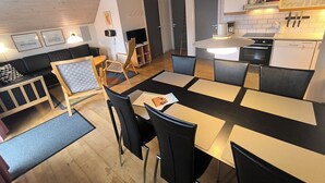 Een modern interieur met een eethoek, keuken en zithoek.