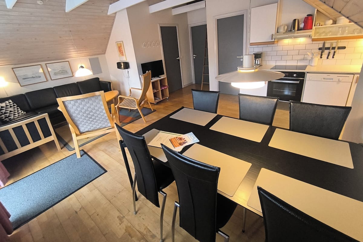 A modern interior with a dining area, kitchen, and seating space.