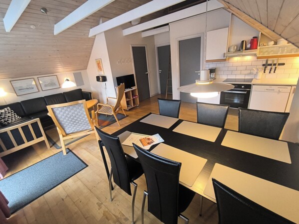 A modern interior with a dining area, kitchen, and seating space.