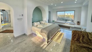 A modern bedroom with a large bed, a view of the outdoors, and a balcony. - Villa les Oliviers 4 Chambres (Manzil Bu Zalafah)