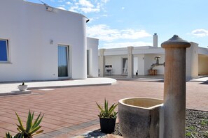 Un edificio moderno con un cortile interno, piante in vaso e un elemento decorativo d'acqua.