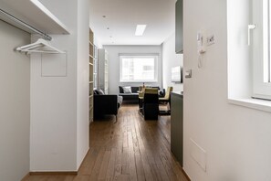 A hallway leading to a living area with a sofa, a table, and a chair. - Leone Central Suite Bari by BarbarHouse (Bari)