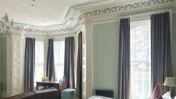 A hotel room with a bed, a sofa, a desk, and a chair. - Central Belfast Apartments Harpers (Belfast)