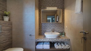 Un baño con lavamanos blanco, espejo y barra para toallas.