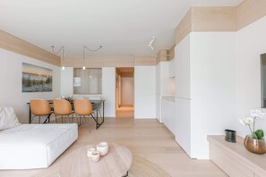A modern apartment with a dining area, a kitchen, and a living room with a sofa and a coffee table. - Stylish coastal apartment for 4 with sea view (Knokke-Heist)