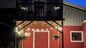 Un bâtiment à deux étages doté d’un balcon, d’une porte rouge et de guirlandes lumineuses.