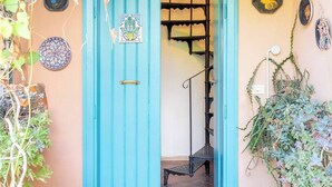A turquoise door with a decorative plate, a hanging lantern, and a staircase leading inside. - A peaceful haven on Rome's doorstep (Monte dell'Ara-Valle Santa)