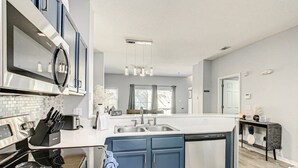 Een moderne keuken met een centraal eiland, roestvrijstalen apparatuur en een vaatwasser.