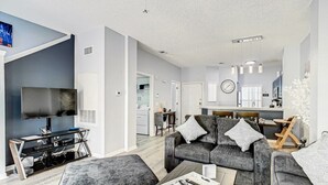 Een moderne woonkamer met een grijze bank, een salontafel en een televisie.