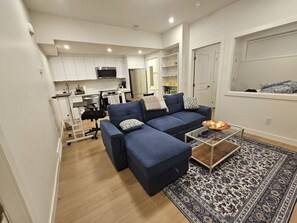 A modern living room with a sectional sofa, a coffee table, and a patterned rug.
