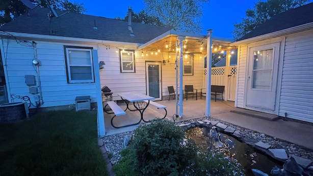 A backyard with a picnic table, a small pond, and string lights. - Blue Door Cottage on Webster (Hastings)