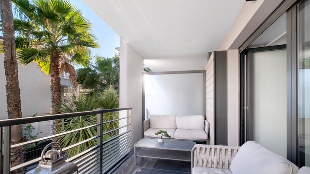 Un balcon avec un canapé, une table et une rambarde.