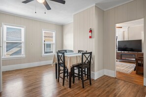 Ein Essbereich mit Tisch und Stühlen, einem Deckenventilator und einem Feuerlöscher an der Wand.
