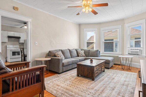 Ein Wohnzimmer mit Sofa, Couchtisch und Deckenventilator.