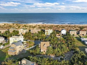 Zona residencial costera con casas, una playa y cielo despejado.