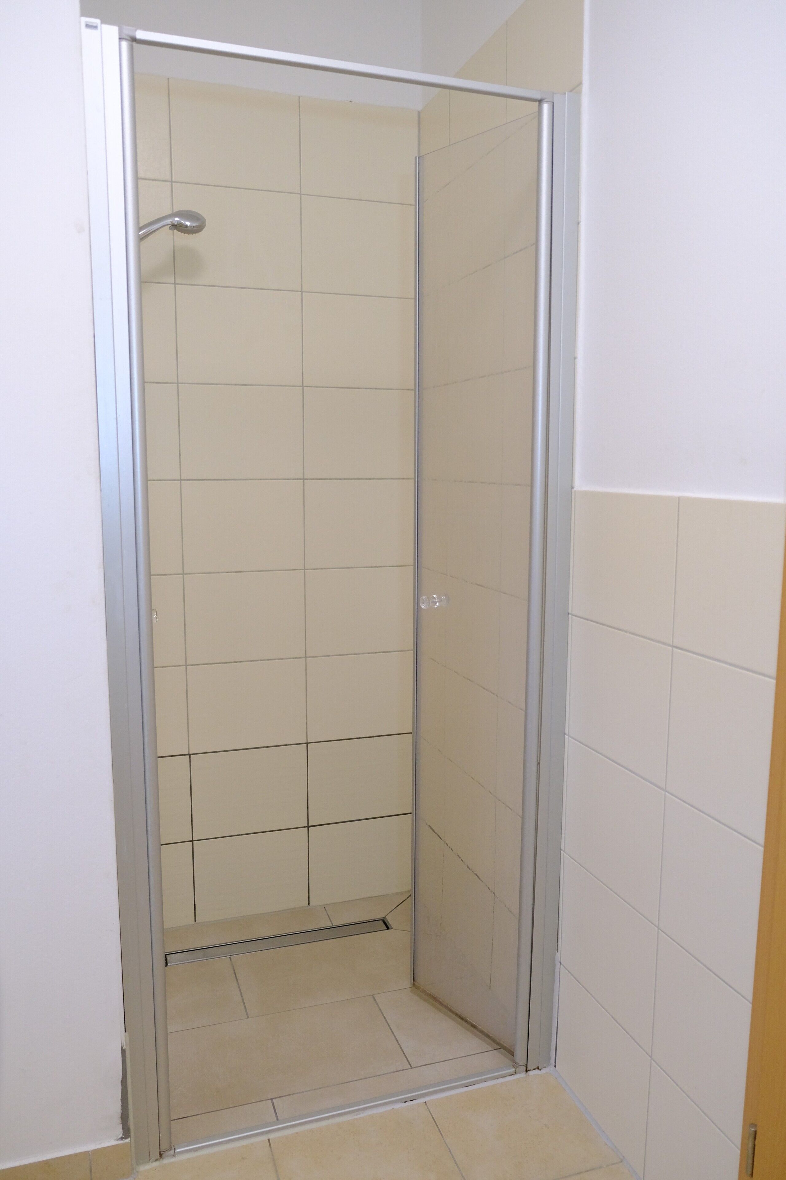 A small, enclosed shower area with a glass door and a showerhead.