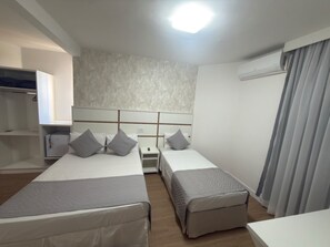 A hotel room with two beds, a wardrobe, a desk, and an air conditioning unit. - GRANCENTRO HOTEL (Mogi-Guacu)