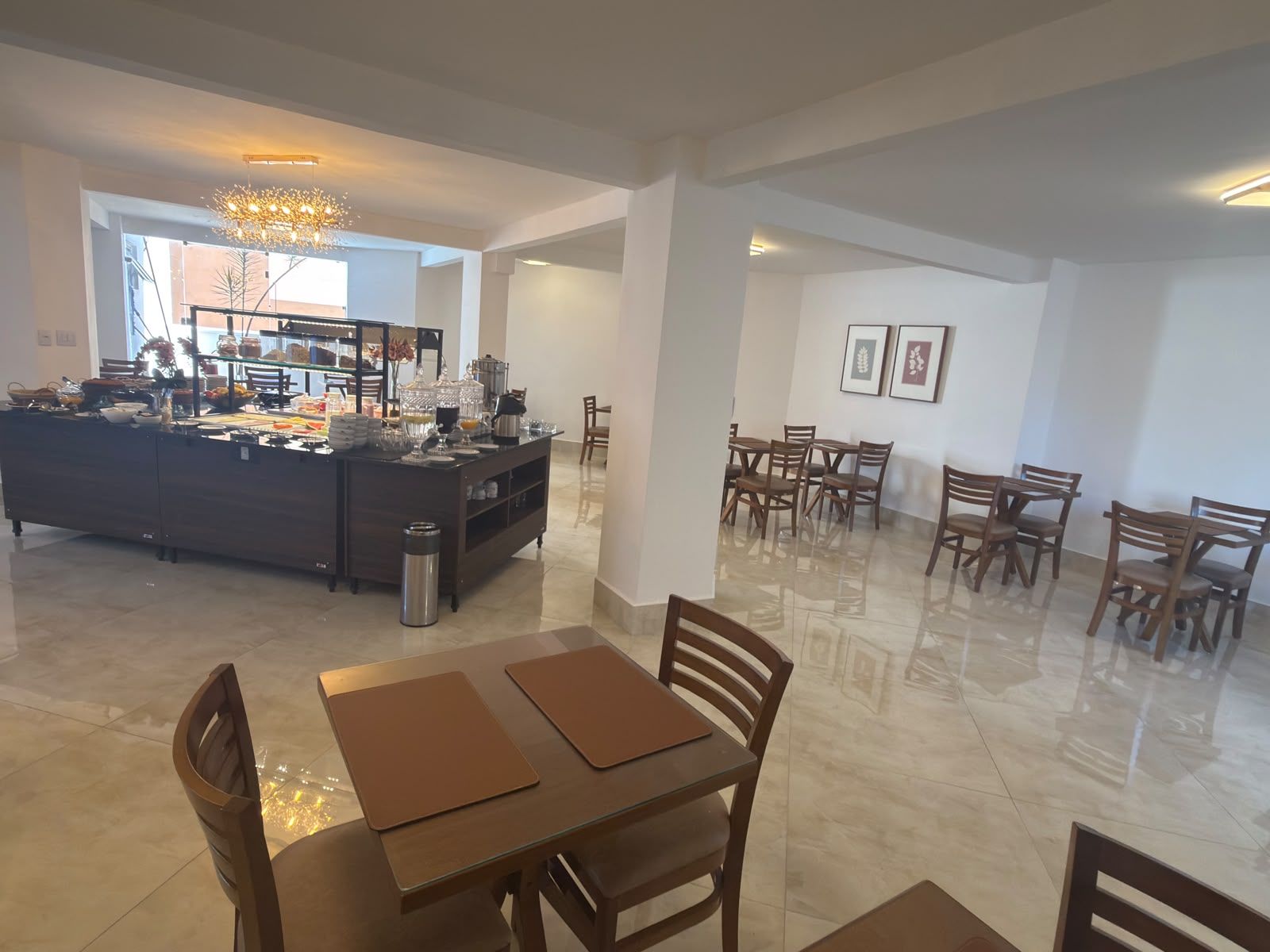 A spacious dining area with a central island, multiple tables, and chairs.