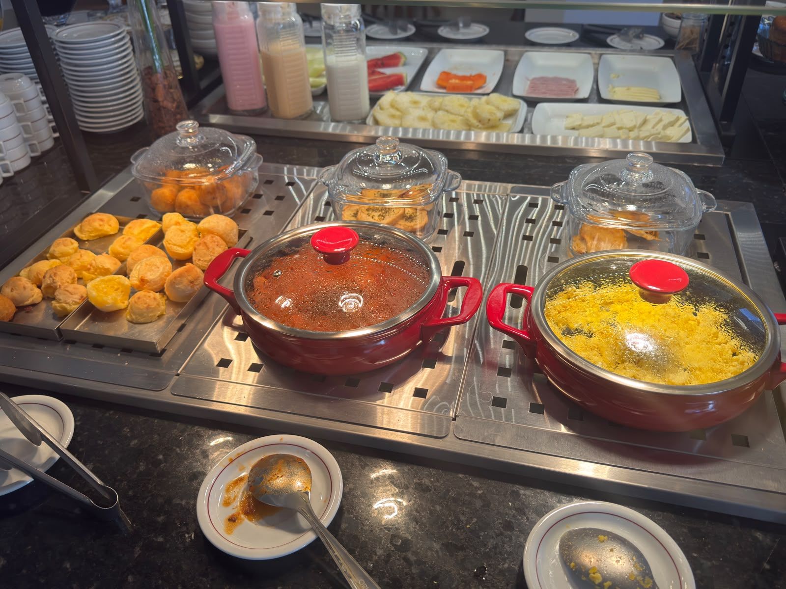 A buffet with various food items and sauces.