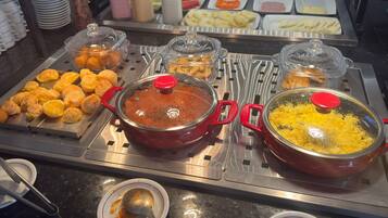A buffet with various food items and sauces.