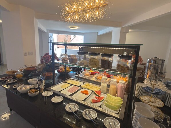 A buffet with various food items and a coffee station. - GRANCENTRO HOTEL (Mogi-Guacu)