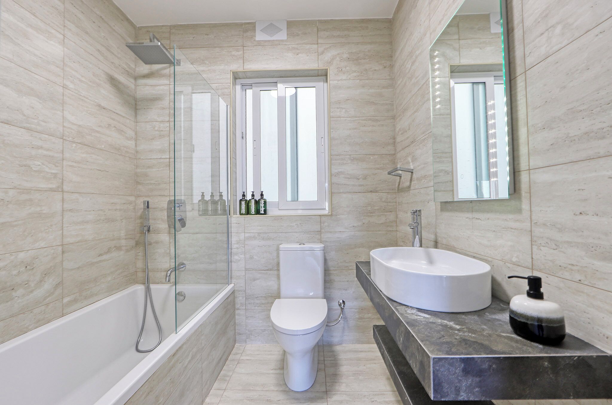 Une salle de bain moderne avec une baignoire, des toilettes et un lavabo.