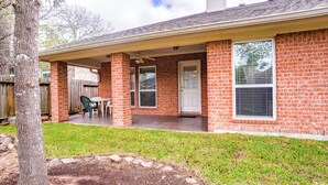 A residential house with a brick exterior, a covered patio, and a front door. - Beautiful 3-bedroom house in The Woodlands (Spring)