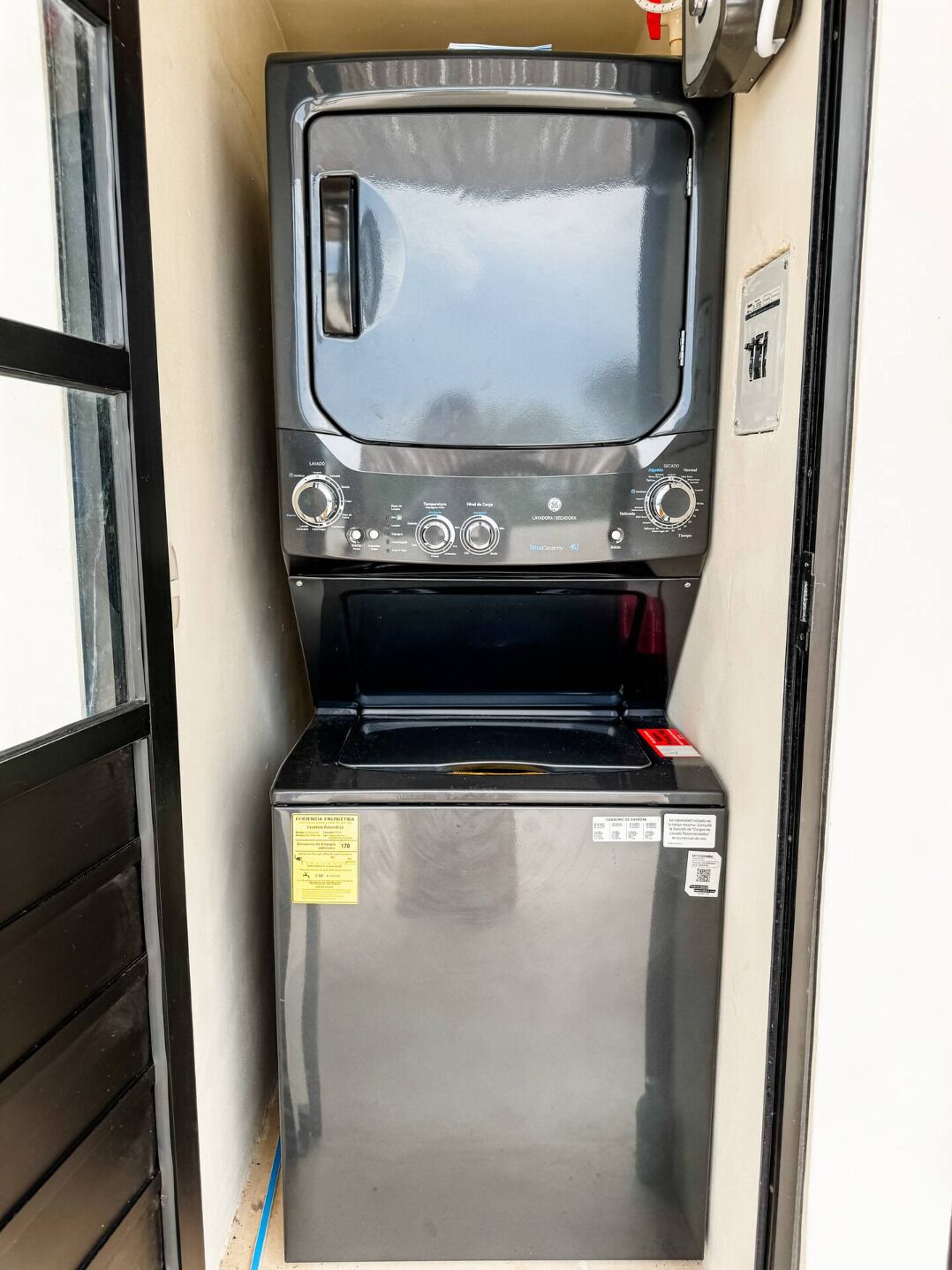 Una kitchenette compacta con microondas y refrigerador de acero inoxidable.
