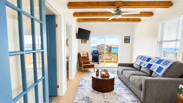A living room with a sofa, a coffee table, and a TV. - Wild Cove Retreat & Nook (Twillingate)
