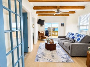 A living room with a sofa, a coffee table, and a TV.
