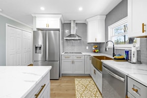Una cocina moderna con armarios blancos, electrodomésticos de acero inoxidable y salpicadero.