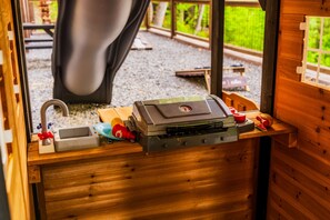 A compact kitchenette with a sink, a small stove, and a window overlooking a gravel area. - 5*Retreat w/Indoor Pool~FirePit~Arcade~Playground (Sevierville)