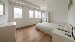 A bedroom with a bed, a dresser, a nightstand, a lamp, and a chandelier. - Apartment inside the Wall of Lugo, Rúa Nova (Lugo)