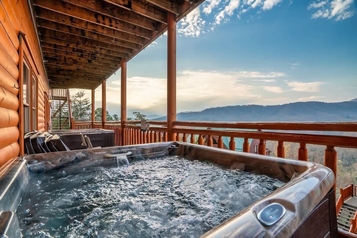 A hot tub on a wooden deck with a view of mountains.