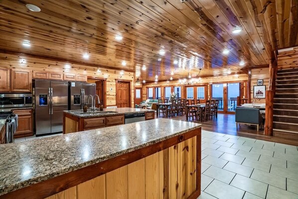 A spacious kitchen with granite countertops, stainless steel appliances, and wooden cabinetry. - 12-Bedroom Cabin with Indoor Pool & Hot Tub, Sleeps 40, Near Pigeon Forge (Pigeon Forge)