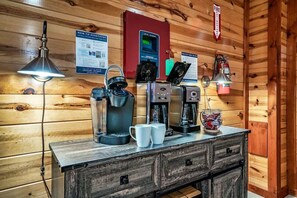 A wooden cabin interior with a coffee station featuring a coffee maker, kettle, and mugs. - Sleeps 40 | 12BR, Indoor Pool, 2 Hot Tubs (Pigeon Forge)