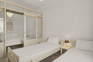 Ein Schlafzimmer mit einem Einzelbett, einem Nachttisch, einer Lampe und einem Schrank mit Spiegel.
