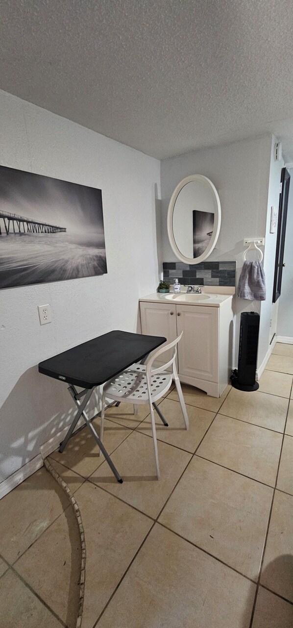 A small, clean room with a desk, chair, and a large mirror.