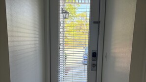 A white door with a window, a textured wall, and a patterned rug. - Enjoy beach life in a 3-bedroom condo in gorgeous Blue Mountain Beach on 30a. (Santa Rosa Beach)