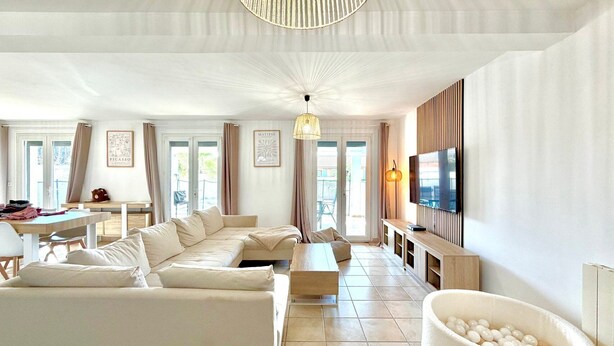 A spacious living room with a sofa set, a TV, and a unique white pet bed. - Le Jardin Bleu, 6-person villa swimming pool (Saint-Geniès-de-Malgoirès)